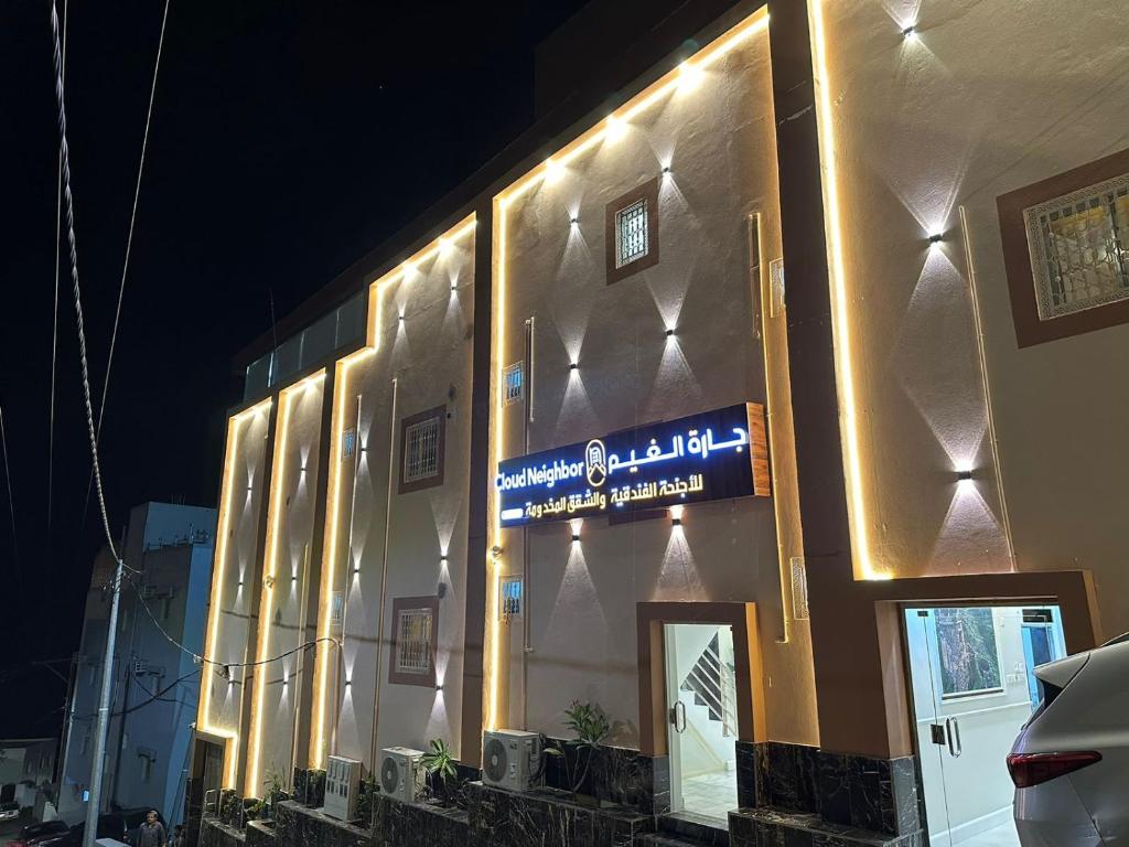 un bâtiment avec un panneau sur son côté dans l'établissement فندق جارة الغيم للاجنحة الفندقية, à Fayfāʼ