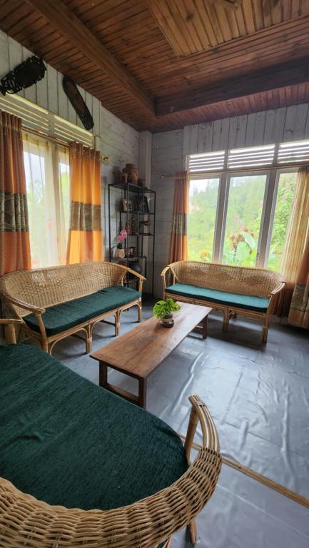 - un salon avec des chaises, des tables et des fenêtres dans l'établissement Serenity homestay, à Mamasa