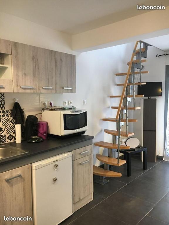 une cuisine avec un four micro-ondes sur un comptoir et un escalier dans l'établissement Escale à Castelnaudary, à Castelnaudary