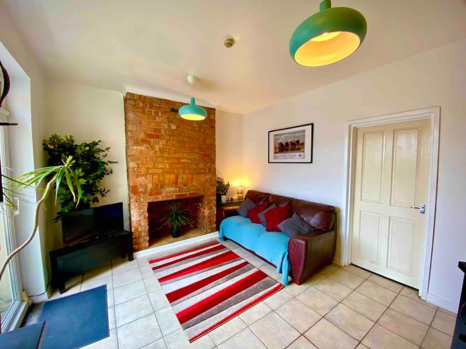 a living room with a couch and a fireplace at Brickworks - 2 bedrooms, 15 mins walk to the centre, with garden in Cardiff