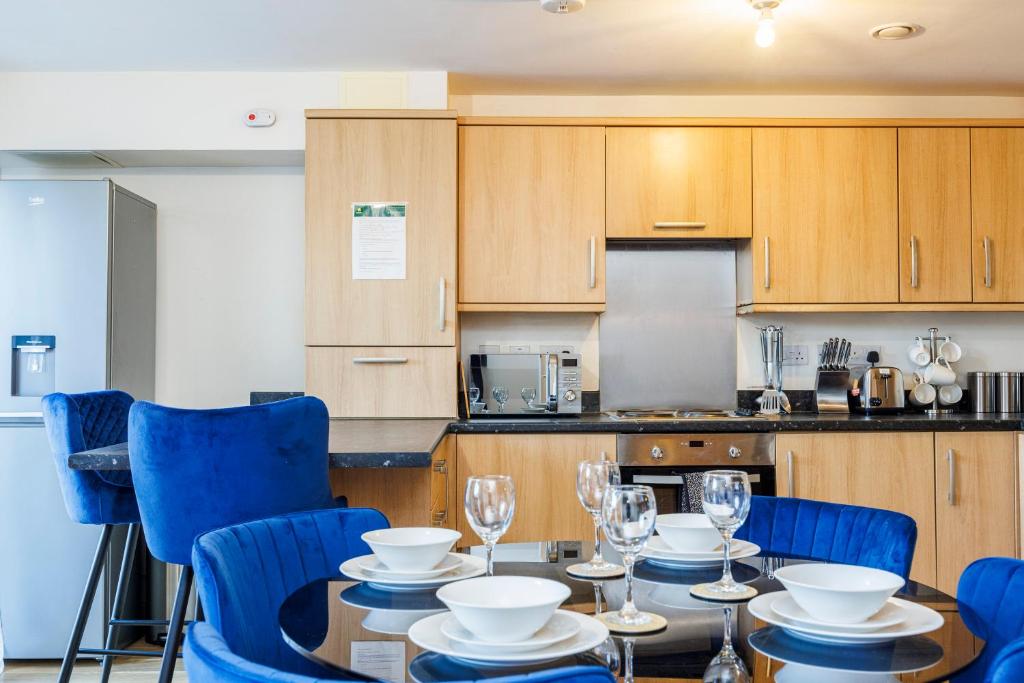 a kitchen with a table and blue chairs in a kitchen at Beautiful Large rooms in Ashford in Willesborough