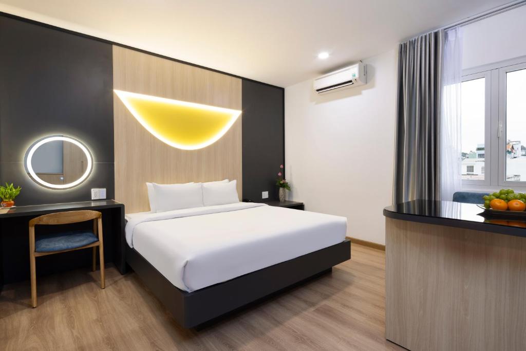 Habitación de hotel con cama, escritorio y espejo. en Sen Viet Hotel, en Ho Chi Minh
