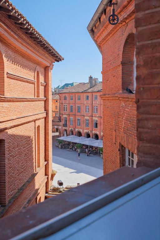 a view of a courtyard from a brick building at Numéro 6 - Place Nationale - Wifi et Fibre in Montauban