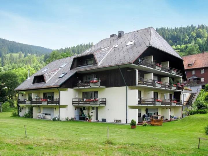 ein großes weißes Gebäude mit grauem Dach in der Unterkunft Ferienwohnung Schwinbachblick Menzenschwand in St. Blasien