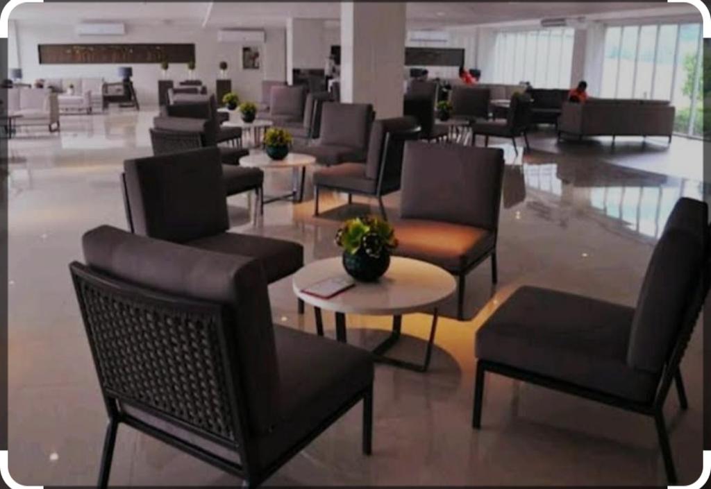 eine Lobby mit Stühlen und Tischen in einem Gebäude in der Unterkunft Four Angels' 2 Bedroom in Manila
