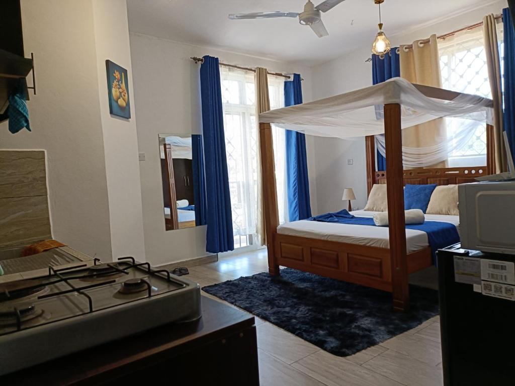 モンバサにあるAffordable neat studio furnished apartment in Mtwapaの天蓋付きベッドのある寝室