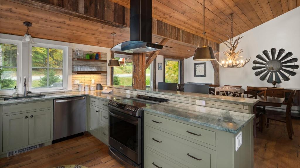 a kitchen with white cabinets and a stove top oven at Orsinis At Mad House condo in Warren
