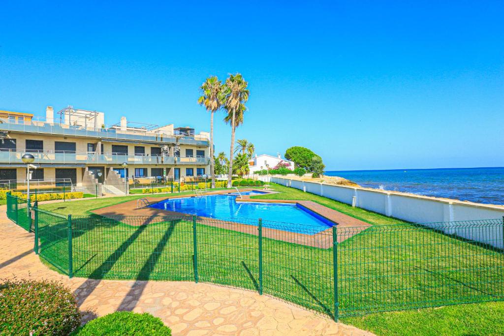 a fence around a swimming pool next to the ocean at Di Mare Litoral Costa Dorada - ONLY FAMILIES in Montroig