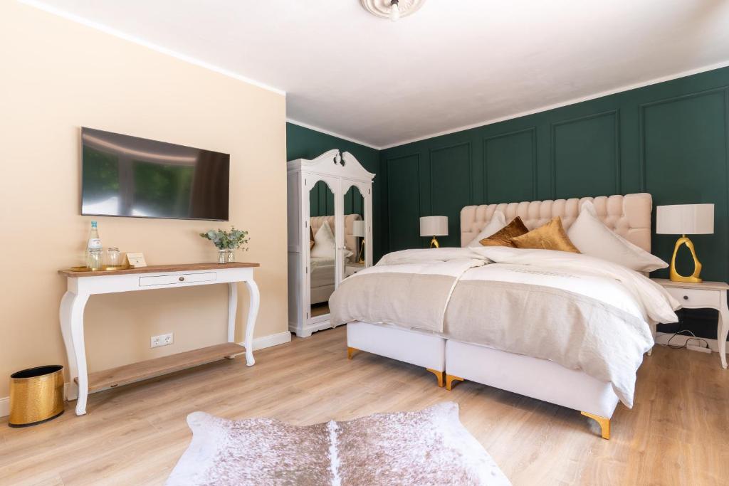 a bedroom with green walls and a white bed and a mirror at Waldhotel und Restaurant Zeitreise in Bramsche