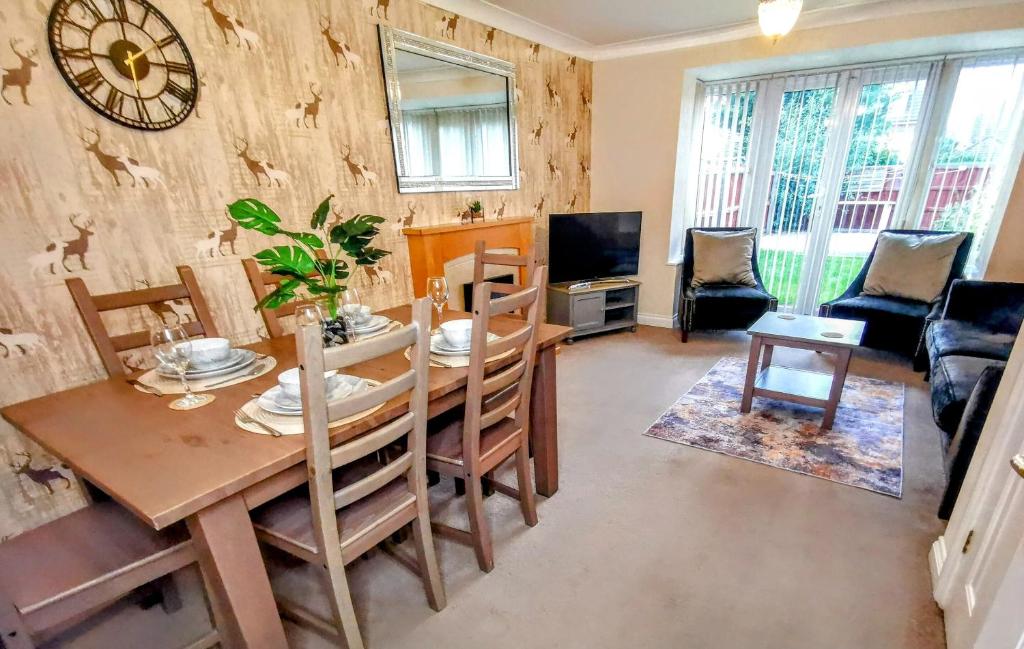 a dining room with a table and chairs and a television at No 23- Large Spacious 3 Bed Home - Parking & WiFi in Nantwich
