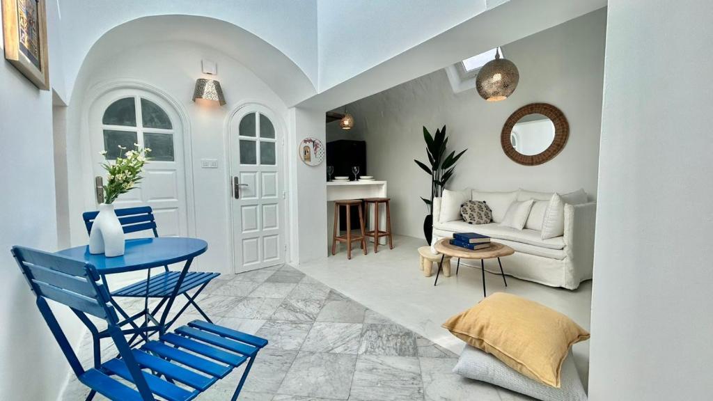 a living room with a blue table and blue chairs at Zina Apartment à Sidi Bou Saïd in Sidi Bou Saïd
