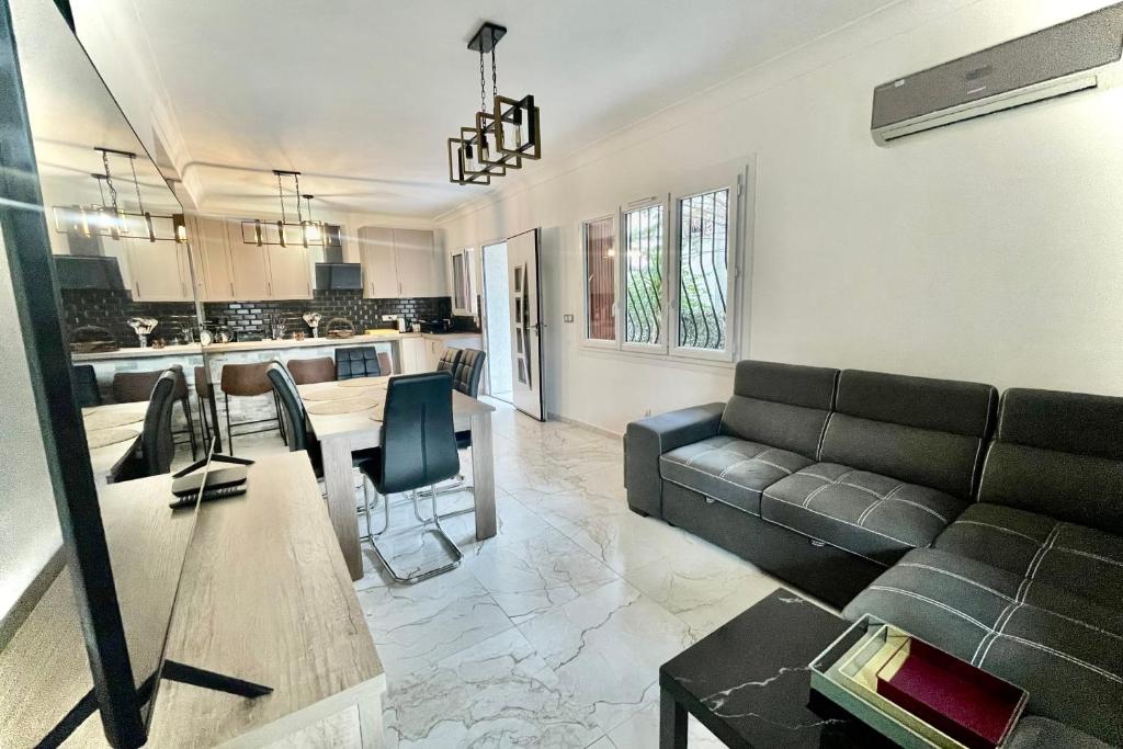 un salon avec un canapé et une table dans l'établissement Modern 3 rooms on the ground floor, à Marseille