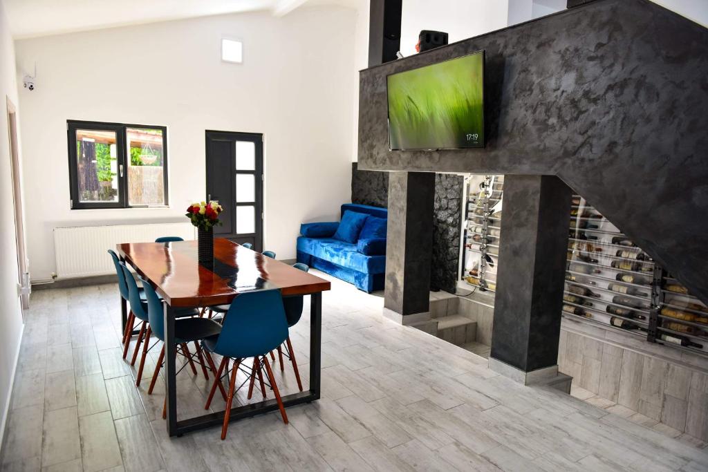 una sala da pranzo con tavolo e camino di UpForest Guesthouse a Călimăneşti