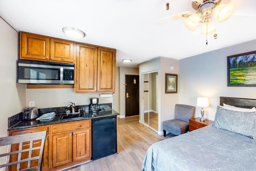 a bedroom with a bed and a kitchen with a sink at Carriage House #215 in Park City