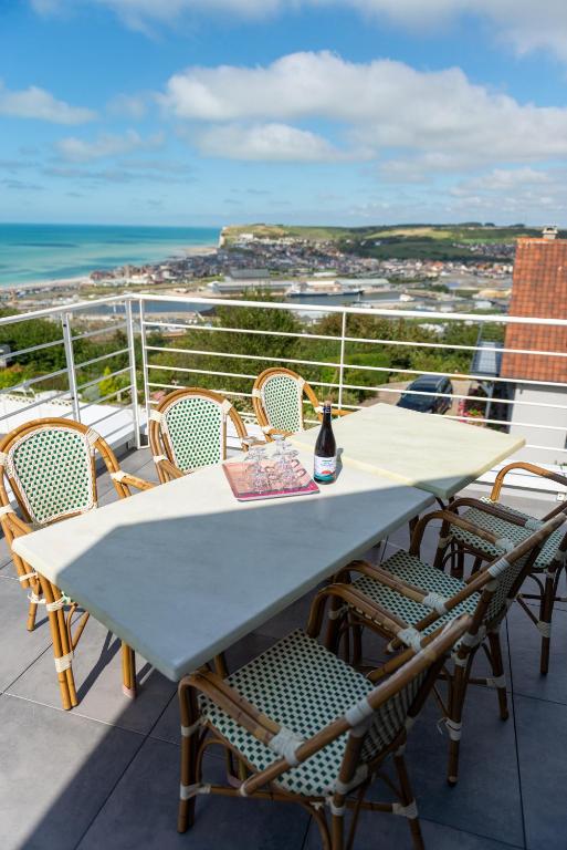 une table et des chaises sur un balcon avec vue sur l'océan dans l'établissement Villa Belle Vue Le Tréport - familiale et spacieuse, au Tréport