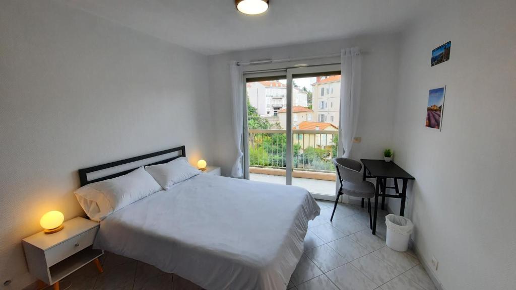 1 dormitorio con cama, escritorio y ventana en Sunny Mercury - Room in Apartment, en Cannes