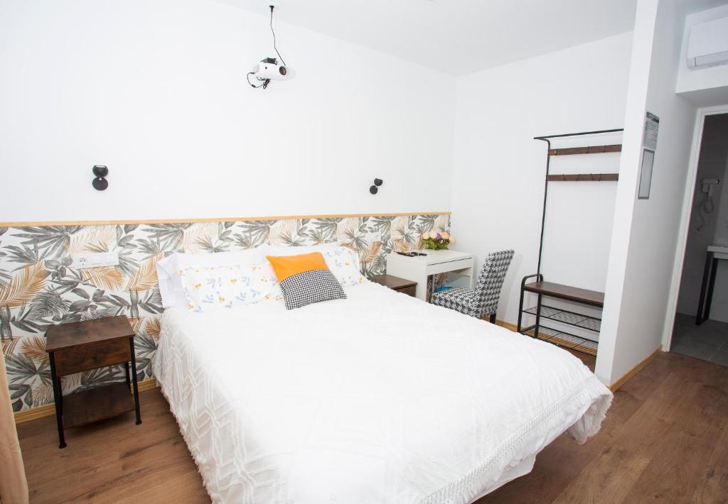 a bedroom with a large white bed and a desk at SG ROOMS in Consuegra