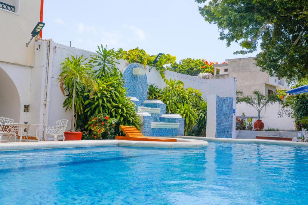 a swimming pool with blue stairs next to a building at Hotel Maria de Lourdes in Cancún