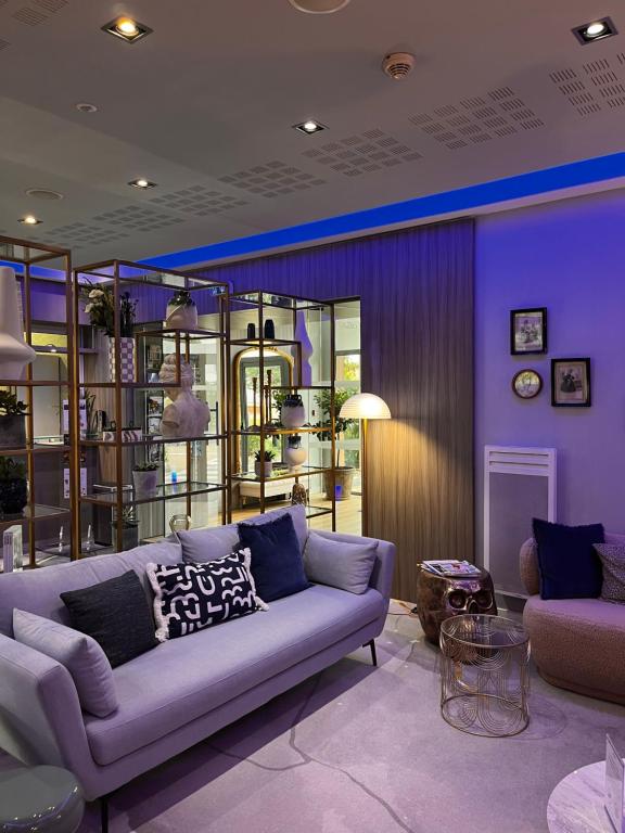 sala de estar con sofá y pared púrpura en Residhome Paris-Guyancourt, en Guyancourt