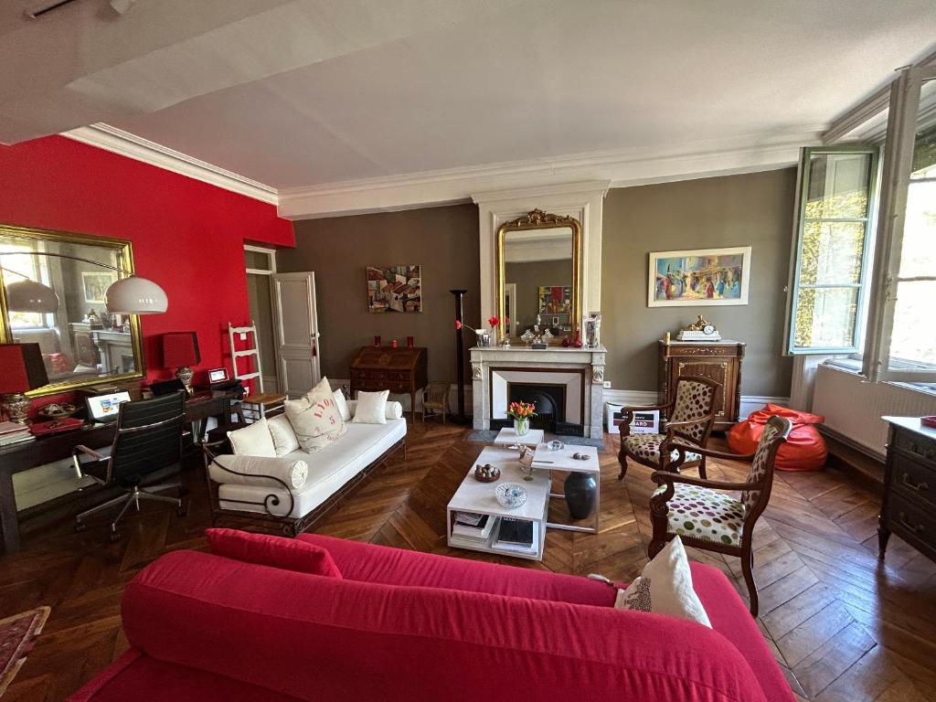 a living room with red walls and a red couch at Les 24 colonnes in Lyon