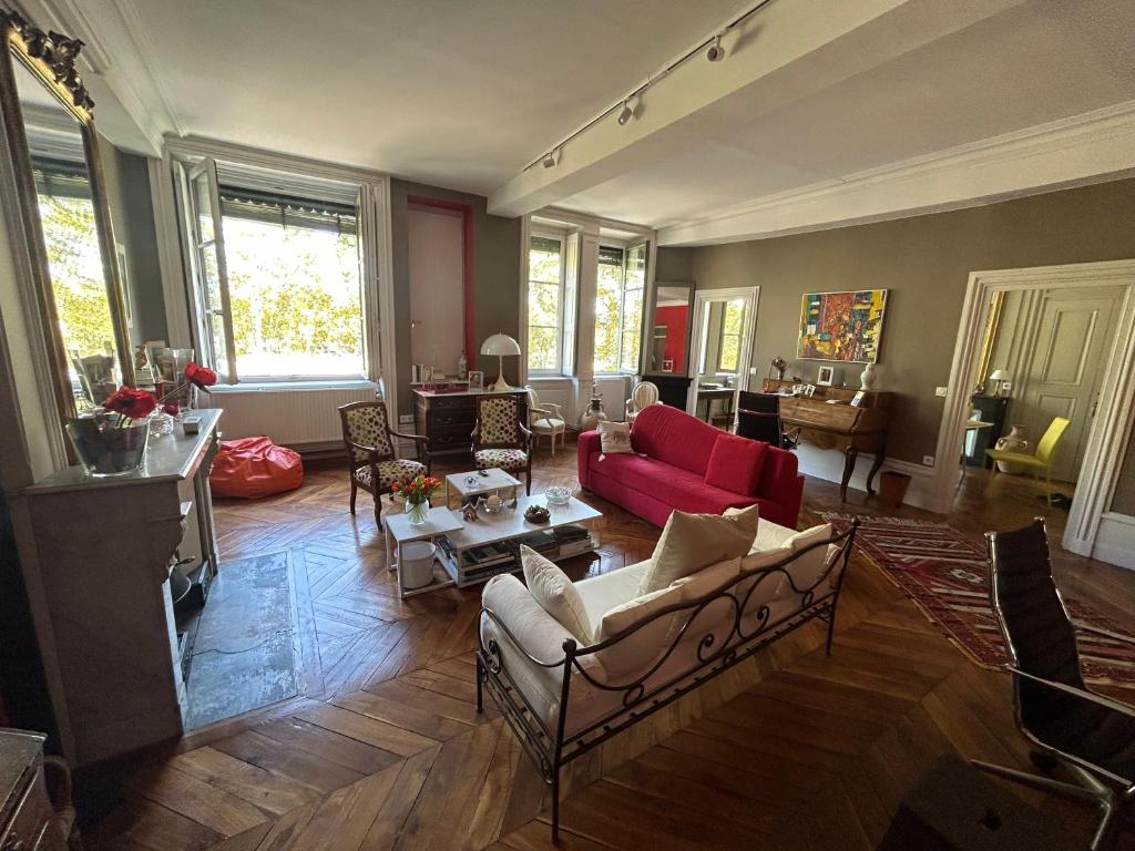 a living room with couches and a red couch at Les 24 colonnes in Lyon