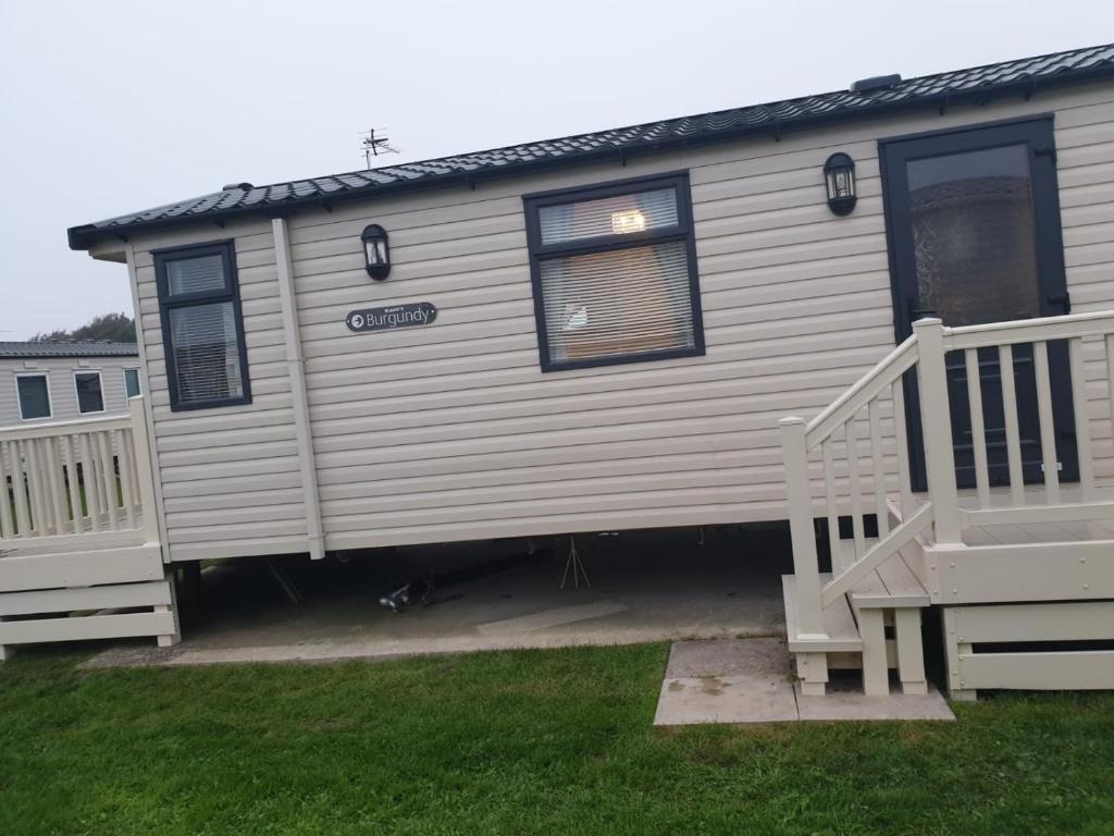 a house with a porch and a staircase in a yard at Swift Burgundy in Prestatyn