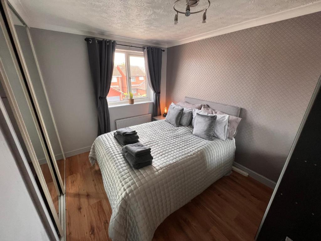 a small bedroom with a bed and a window at CONTRACTORS OR FAMILY HOUSE - M1 Nottingham - IKEA RETAIL PARK - CATKIN DRIVE - 2 Bed Home with Driveway, private garden, sleeps 4 - TV'S in all rooms 