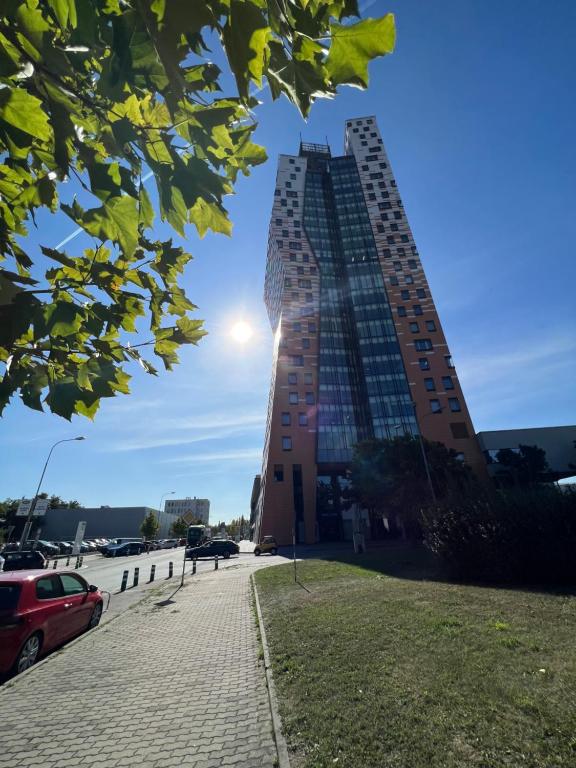 a tall building with the sun in the sky at AZ Tower Apartment in Brno