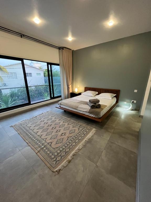 a bedroom with a bed and a large window at Villa moderne à Trou aux Biches in Trou aux Biches