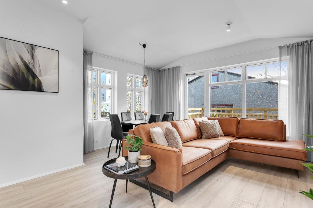 ein Wohnzimmer mit einem braunen Sofa und einem Tisch in der Unterkunft Capital Luxury Apartments in Reykjavík