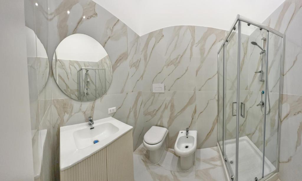 La salle de bains est pourvue d'un lavabo, de toilettes et d'un miroir. dans l'établissement Home Piccini, à Naples