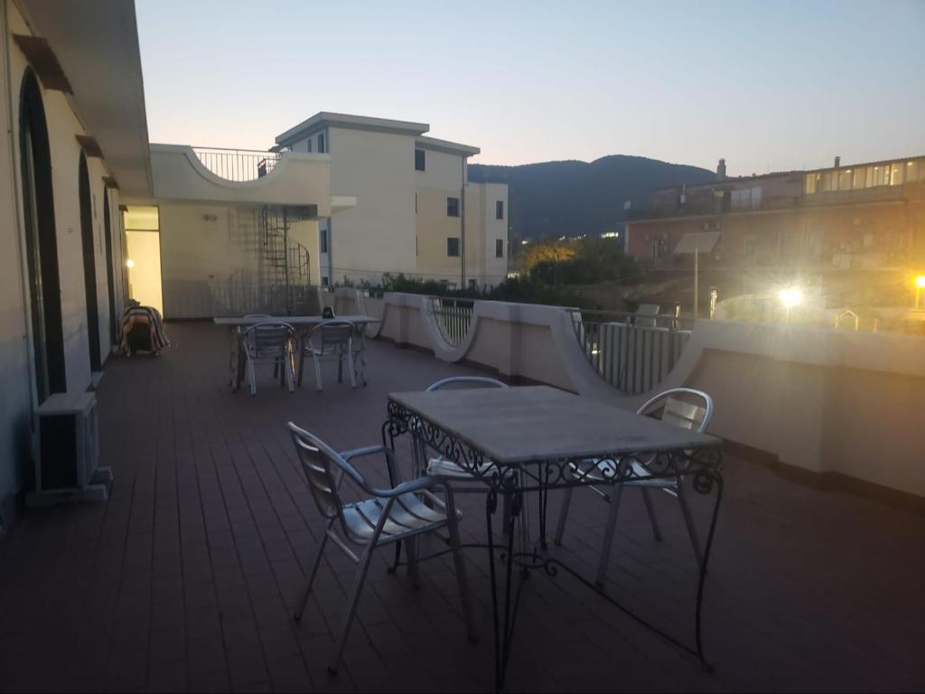 un patio con tavoli e sedie su un balcone di max hotel e restaurant a Pontecagnano