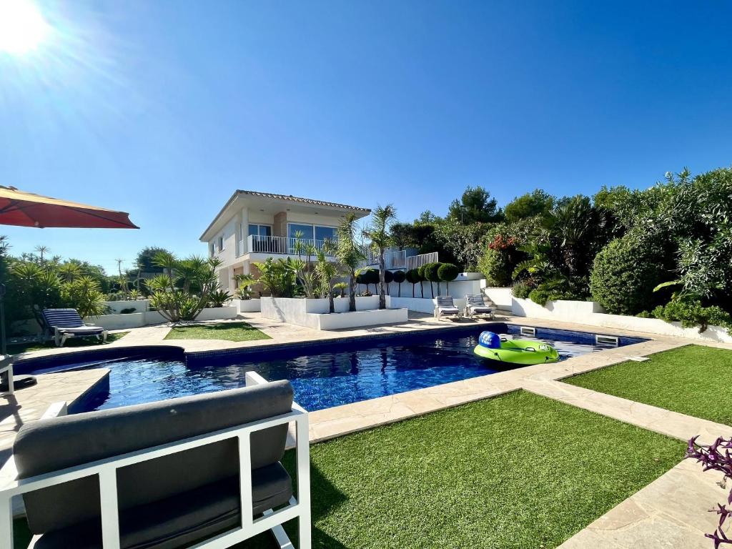 une arrière-cour avec une piscine et une maison dans l'établissement Afortunada - air-conditioning in all bedrooms, à El Perelló