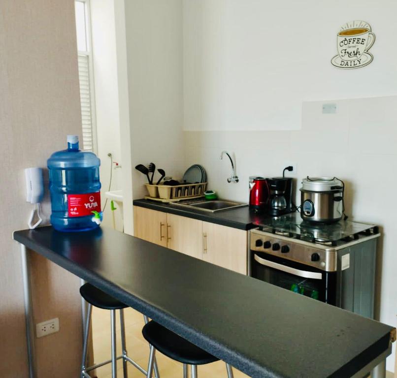 a kitchen with a counter with a water bottle on it at 3J's House in Tarapoto