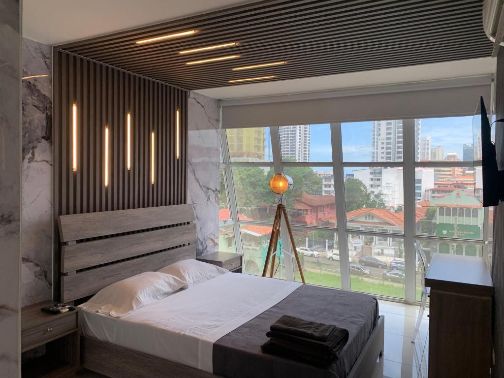 巴拿馬城的住宿－4B - Centríco Divertido FIT 4BR，一间卧室设有一张床和一个大窗户