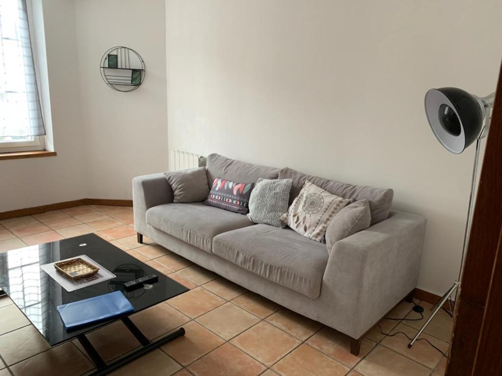 a living room with a couch and a table at Appartement avec terrasse in Gien