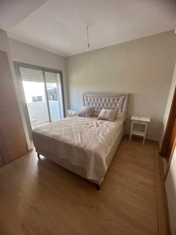 um quarto com uma cama grande e uma janela em Chez khadija et Othman em Tânger