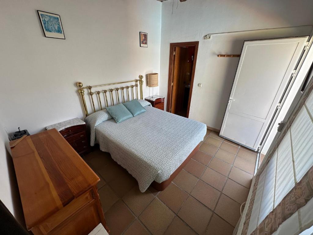 een slaapkamer met een bed, een dressoir en een koelkast bij apartamento acogedor con piscina y chimenea in Nuevo Baztán
