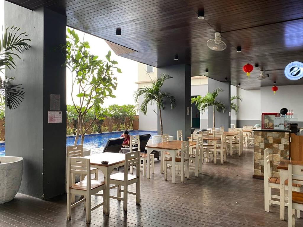 restauracja ze stołami i krzesłami oraz basenem w obiekcie Tamansari Mahogany Apartment By Sagita Residence Karawang w mieście Karawang