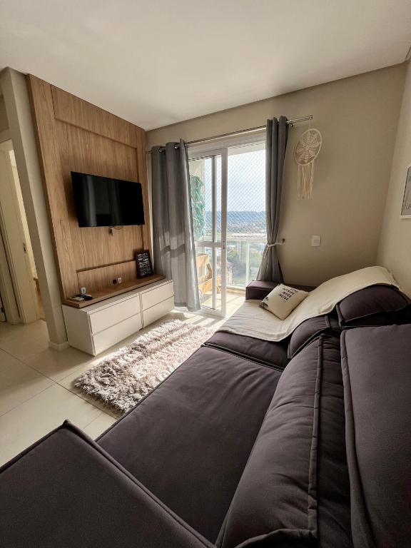 a bedroom with a large bed and a large window at Aconchegante e funcional in Santa Cruz do Sul