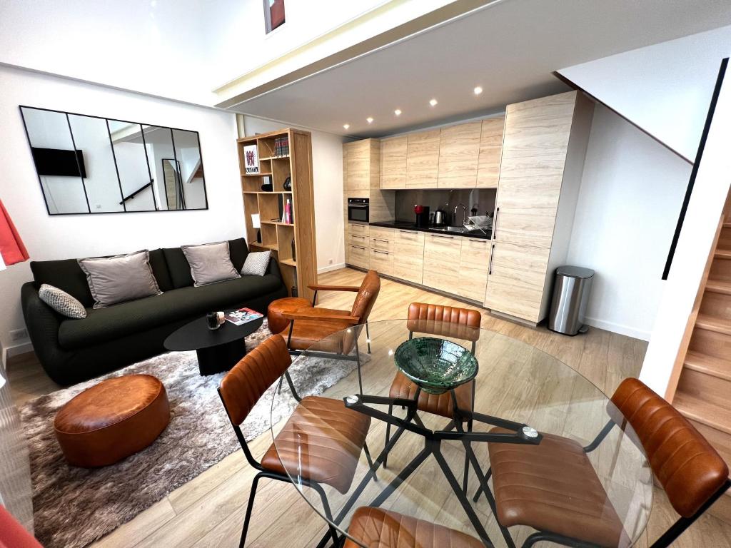 - un salon avec un canapé, une table et des chaises dans l'établissement Apollinaire - Luxury Loft - Heart of Montparnasse, à Paris