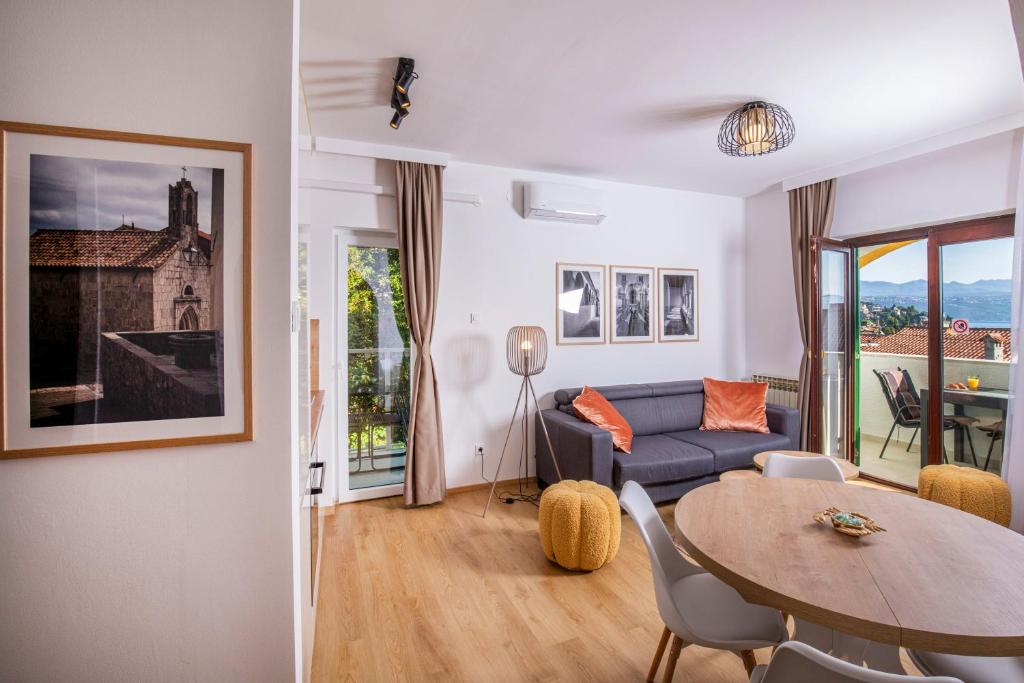 a living room with a blue couch and a table at Villa Beller New in Ičići