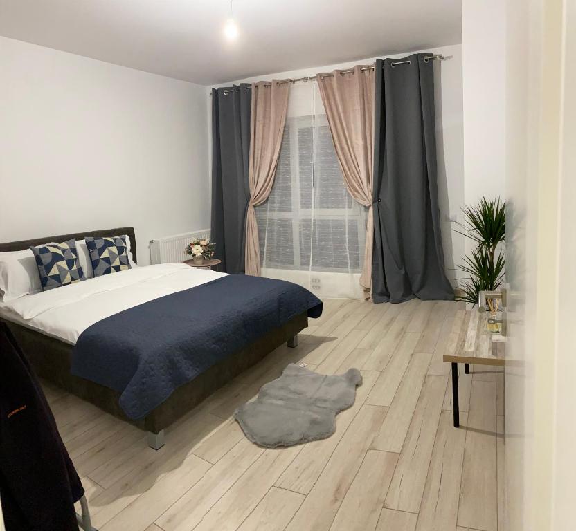 a bedroom with a bed and a wooden floor at Deea H24 in Râşnov