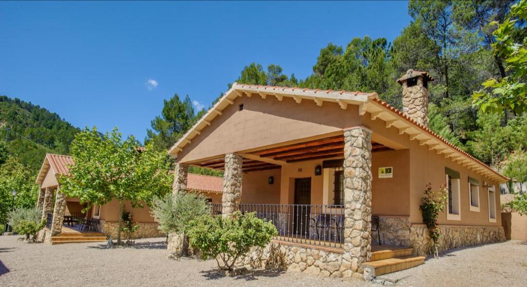 a small house with a porch and a stone at Casas rurales Batan Rio Tus in Yeste