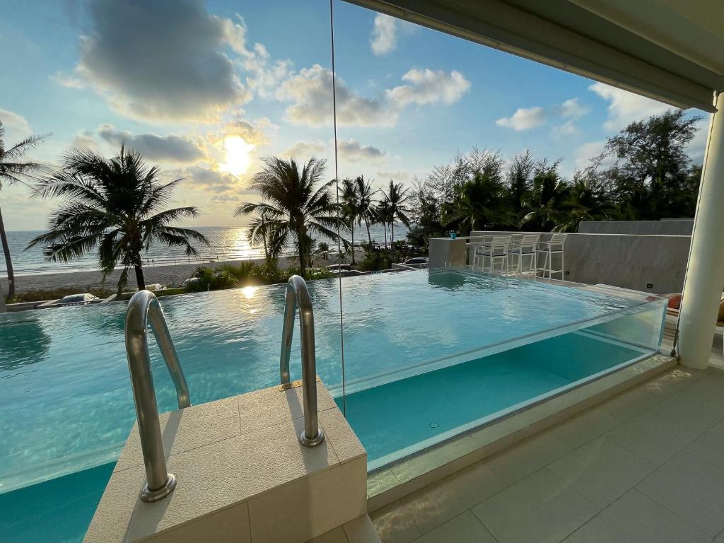 a swimming pool with a view of the ocean at Beachfront Phuket in Bang Tao Beach