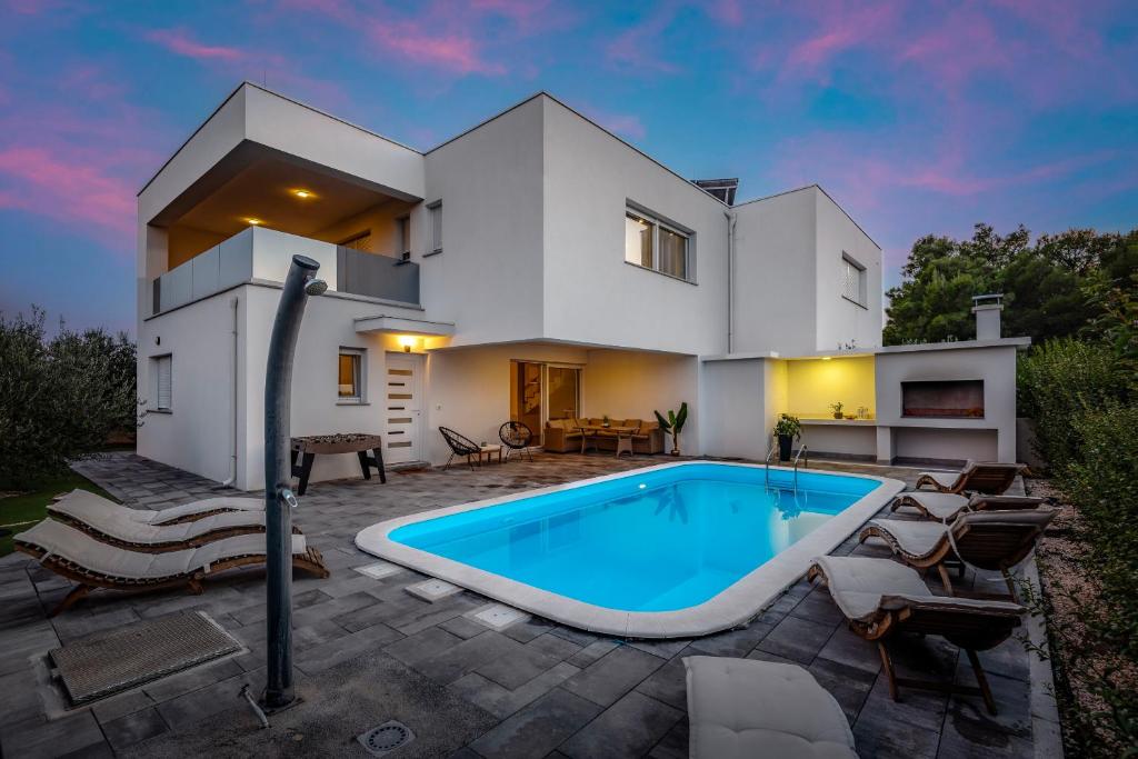 a villa with a swimming pool in front of a house at Villa Loreta in Srima