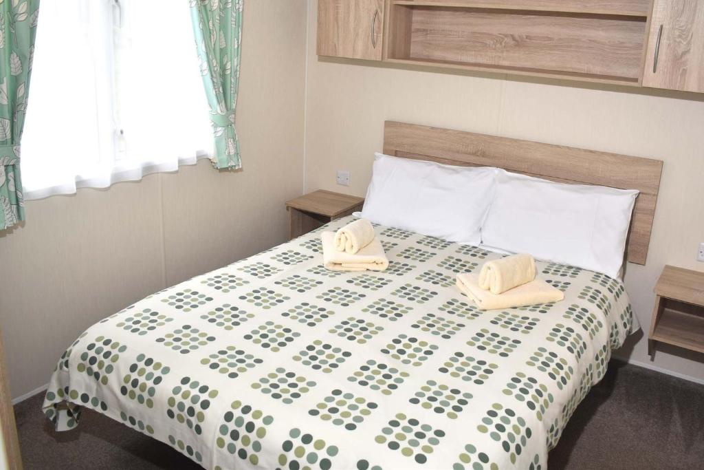 a bedroom with a bed with two towels on it at Rio Gold LC20 in Minehead