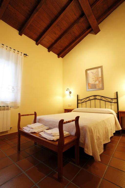 a bedroom with a bed and a table with towels on it at Casa Rural Puerta del Sol II de 2 habitaciones in Candelario