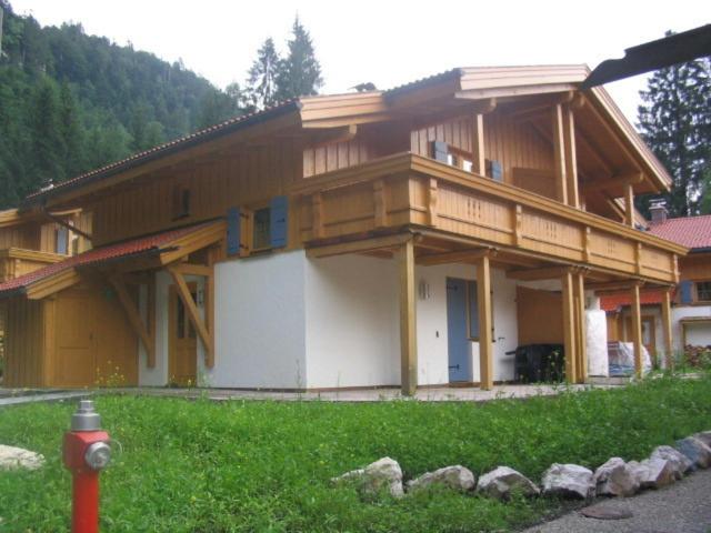 uma casa de madeira com uma boca de incêndio à frente. em Ferienhaus Sachrang em Sachrang