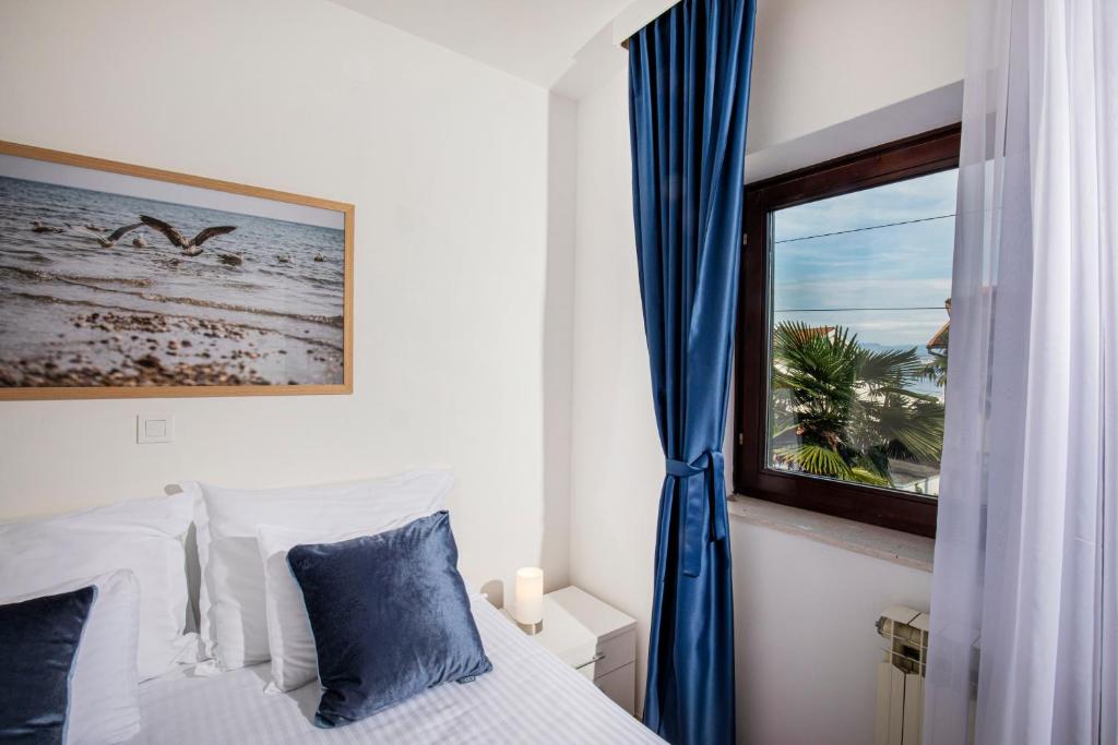 a bedroom with a bed and a window at Villa Beller New in Ičići
